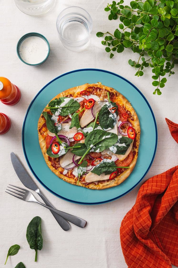 Italiensk pizza med røget kyllingebryst, tomat, rødløg og spinat
