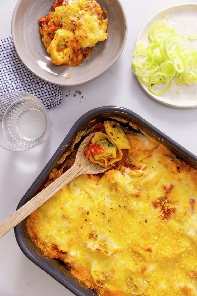 Gratineret ravioli i fad med bacon og porre